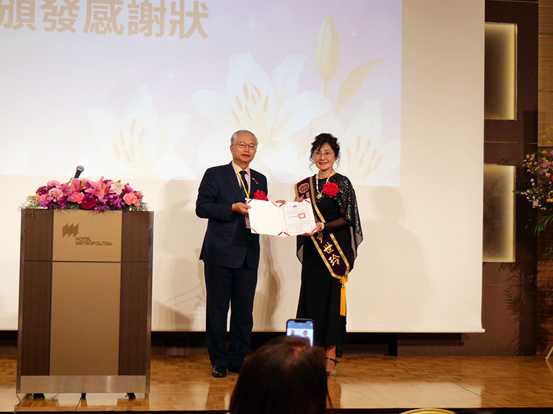 第十一屆會長尹世玲（右）在台上接受致謝與表揚，象徵任期圓滿落實與團隊努力的肯定。